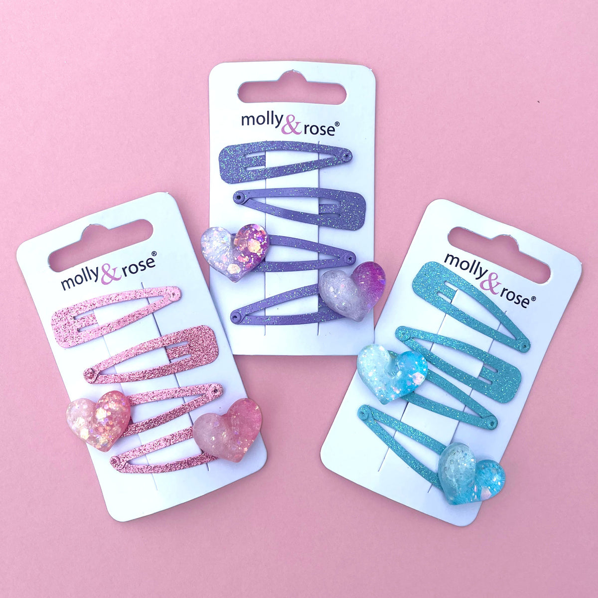 Glitter hair clips with hearts in assorted colours; one pack of four clips included