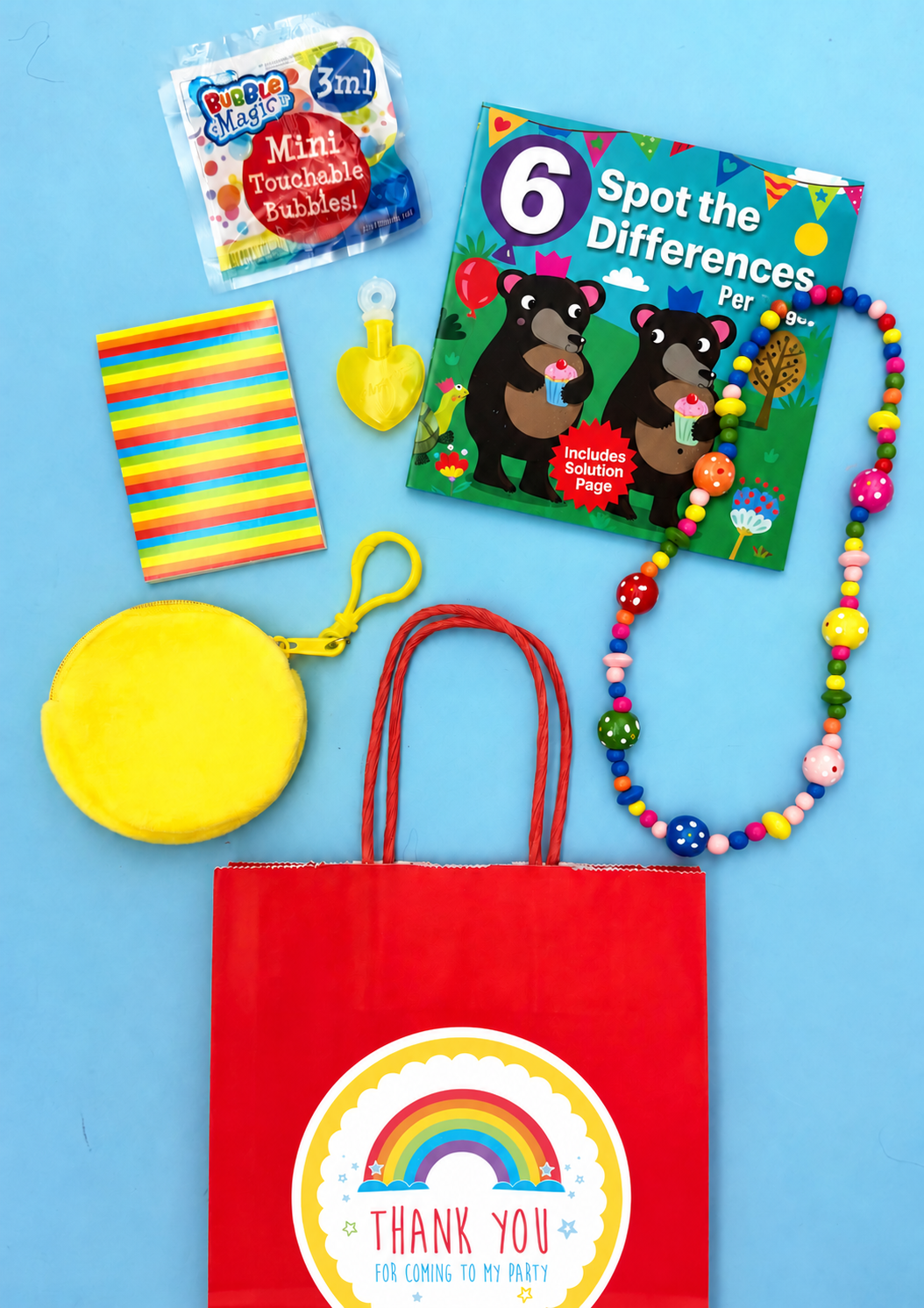 Eliza party bag with Spot the Difference book, wooden bead necklace, yellow purse charm, rainbow memo pad and touchable bubbles; optional packaging shown