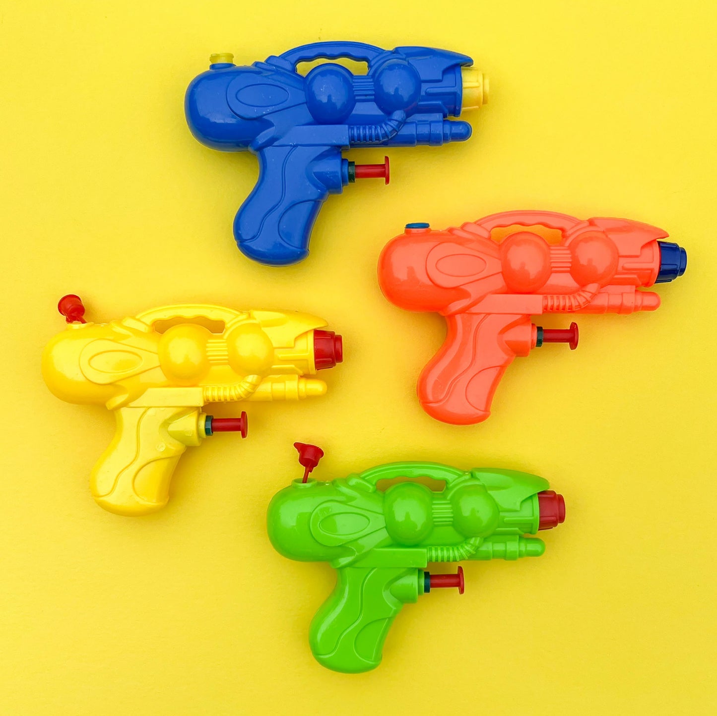 Water pistols in 4 different colours, orange, yellow, blue and green