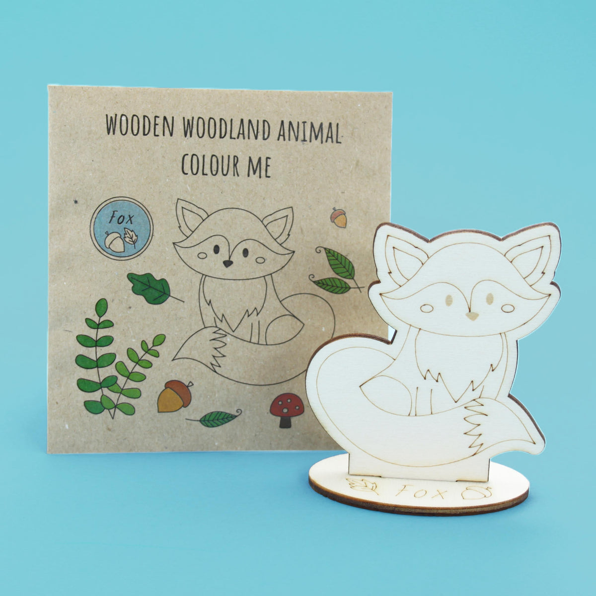 Uncoloured wooden fox with slot-in base and paper packaging; one assorted woodland animal included