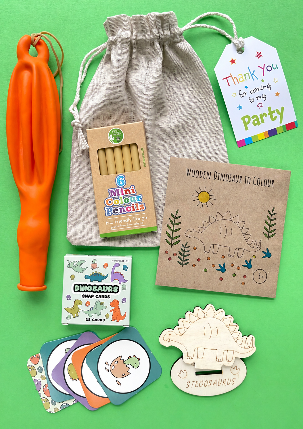 Dinosaur eco cotton party bag with six mini colouring pencils, wooden dinosaur craft, dinosaur snap cards and punch balloon